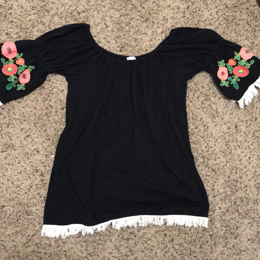 black dress with floral print sleeves and fringe.